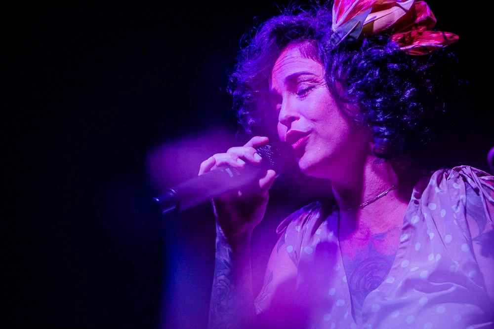 Vocalista e instrumentistas em harmonia durante execução de canção emocionante do espetáculo
